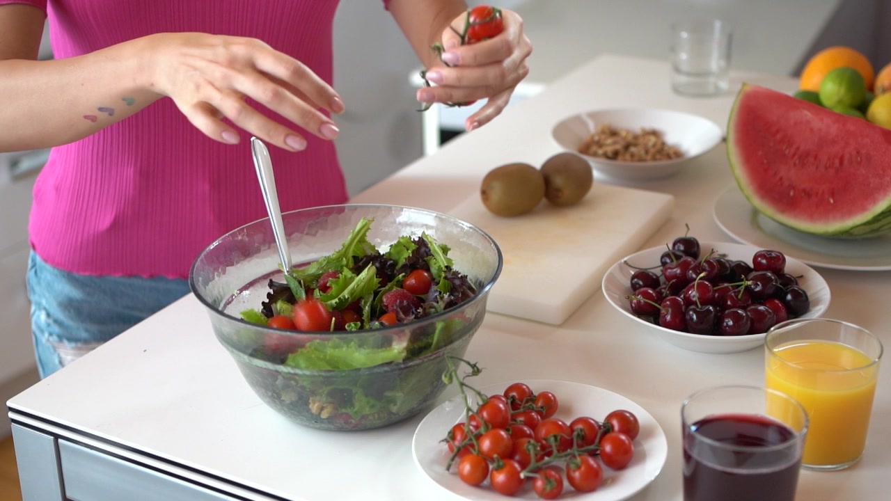 Mulher de colheita preparando salada saudável na cozinha