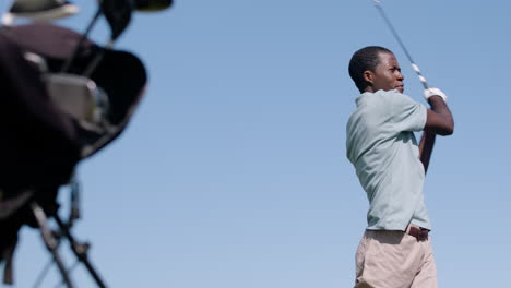 lower view of african american man practicing golf on the golf course.