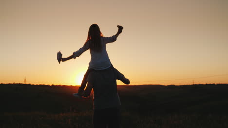 happy father playing with his daughter at sunset