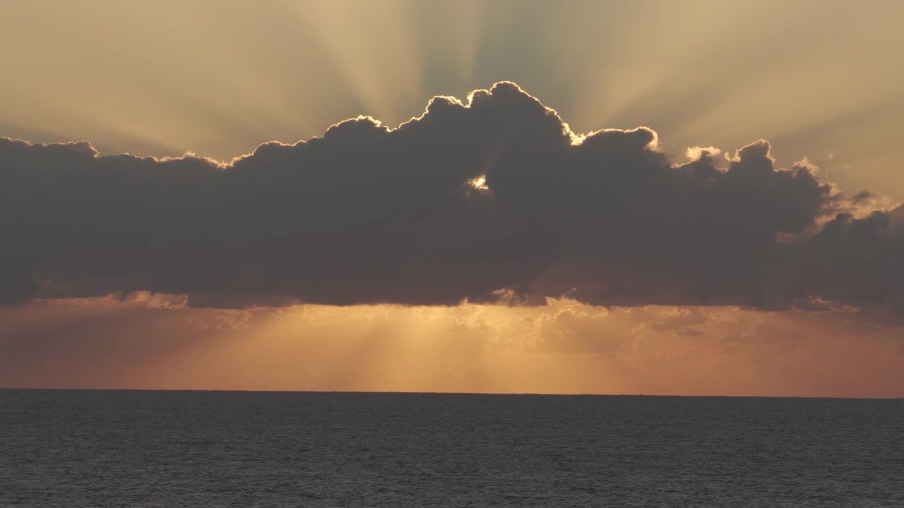 Golden Crepuscular Rays Through Dark Cloud Bank Over The Ocean - Dramatic Sunrise In Queensland, Australia. wide drone shot