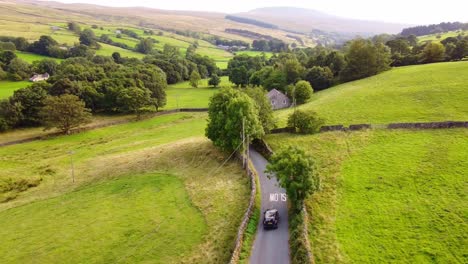 single car drives along countryside road in summer yorkshire dales