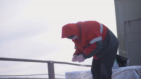 man ice fishing in winter