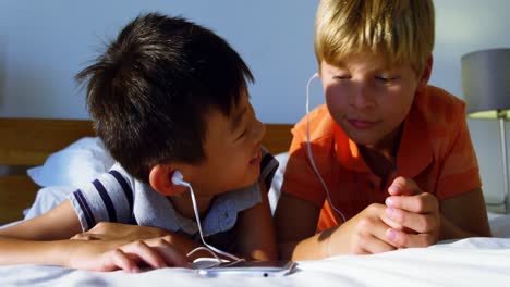 Siblings-using-mobile-phone-in-bedroom