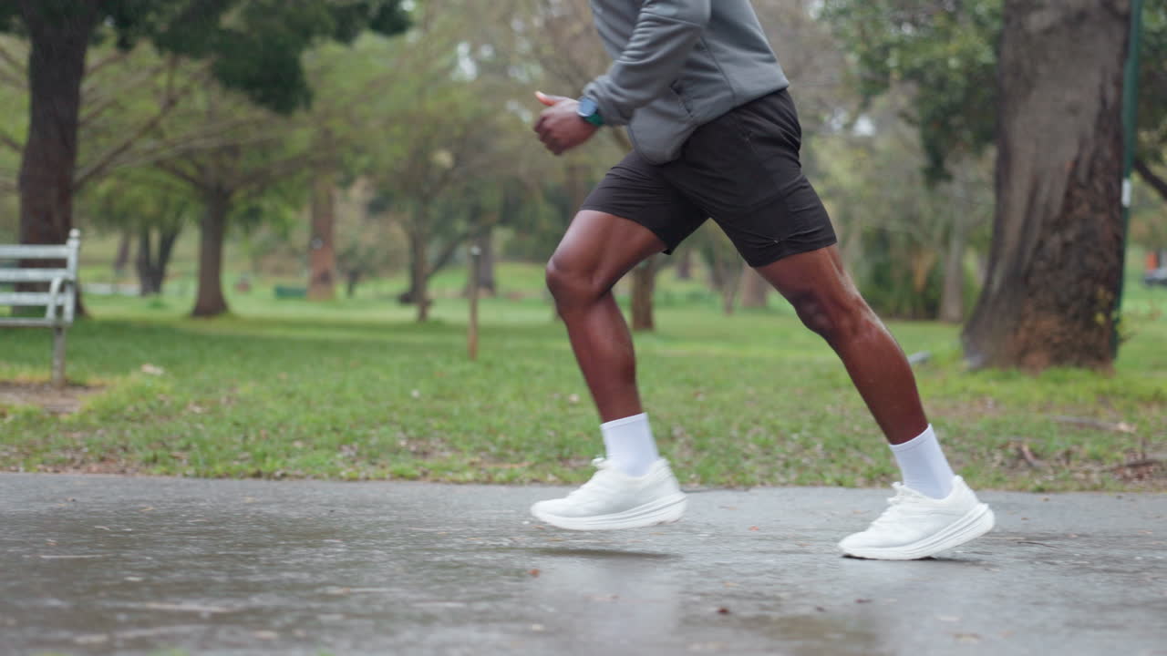 Uomo che corre in un parco in una giornata piovosa
