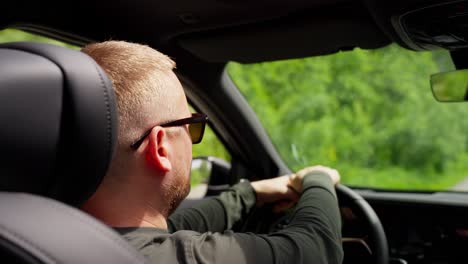 man driving a car through a scenic landscape