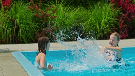 two girls splashing in a pool