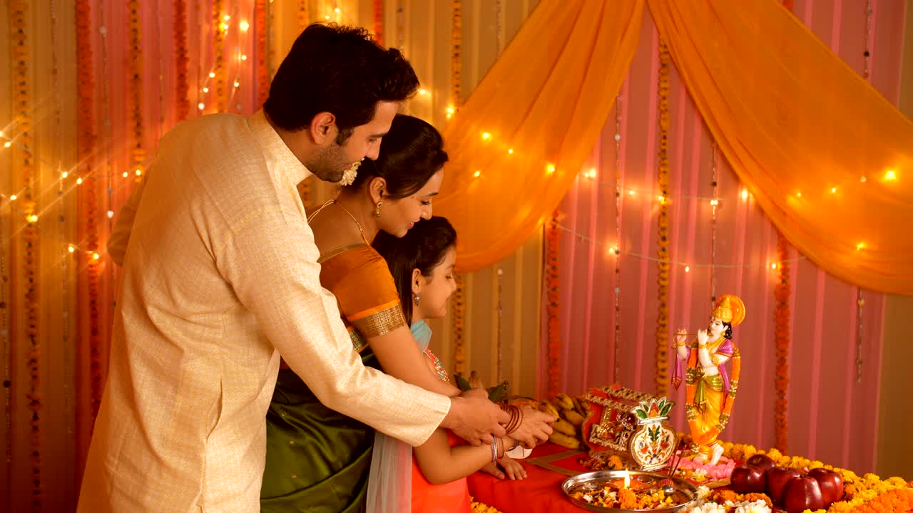 Happy Indian family performing Hindu rituals on the auspicious day of Janamashtmi