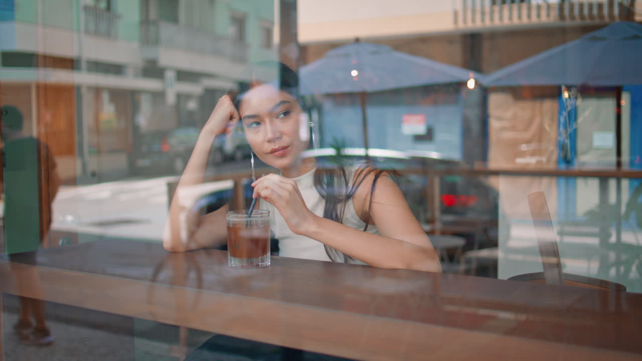 una mujer disfrutando de una copa en un café.