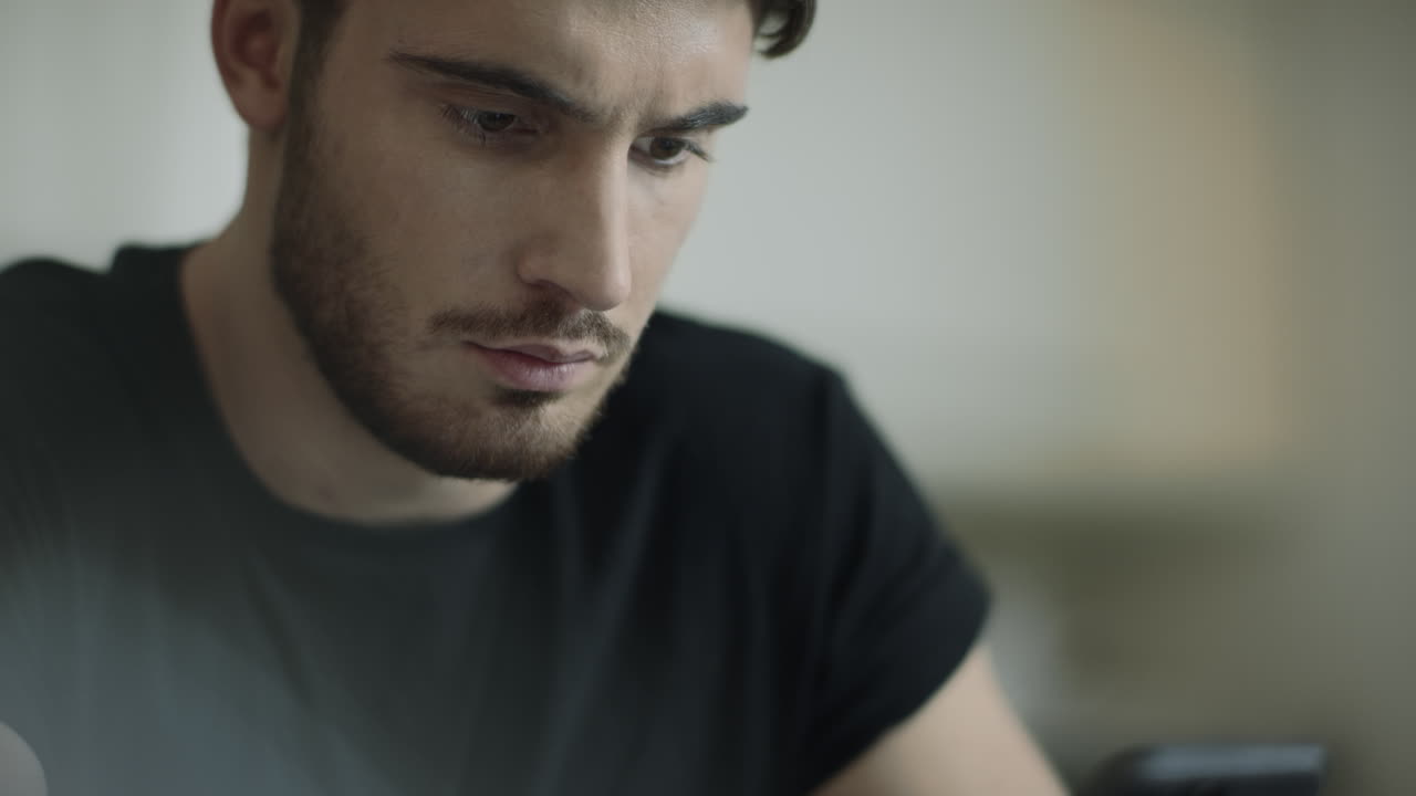 rostro de hombre enfocado mirando el teléfono inteligente