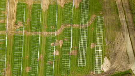 sitio de construcción de granjas fotovoltaicas, campo verde preparado para la construcción de plantas de energía solar - antena arriba hacia abajo