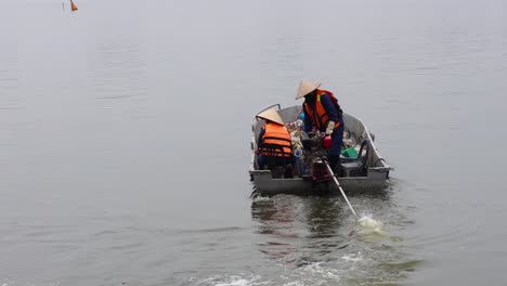 workers rowing boat to collect river garbage