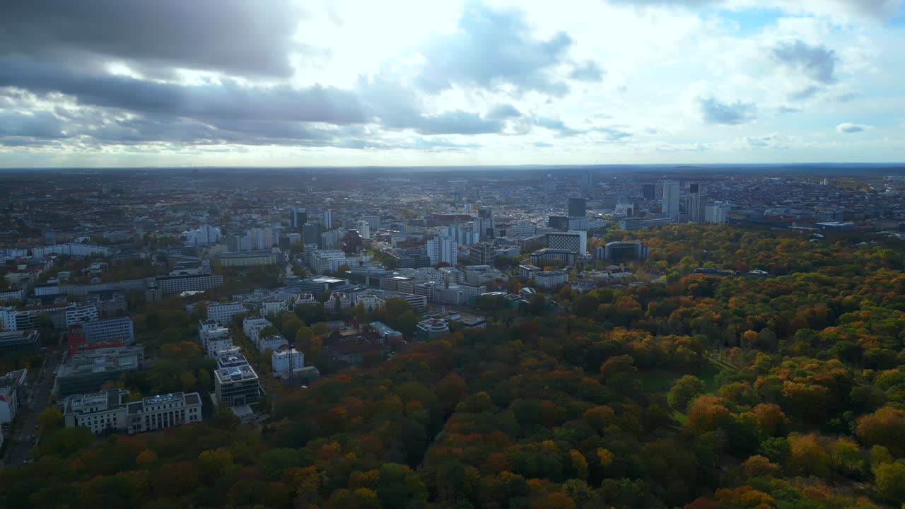 Autumn trees in Tiergarten and the iconic Victory Column gold Else and Bellevue Palace in Berlin. Gorgeous aerial view flight panorama overview rotation pan to right drone
