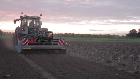 Land-being-tilled-by-tractor,-the-tractor-moves-away-from-the-camera