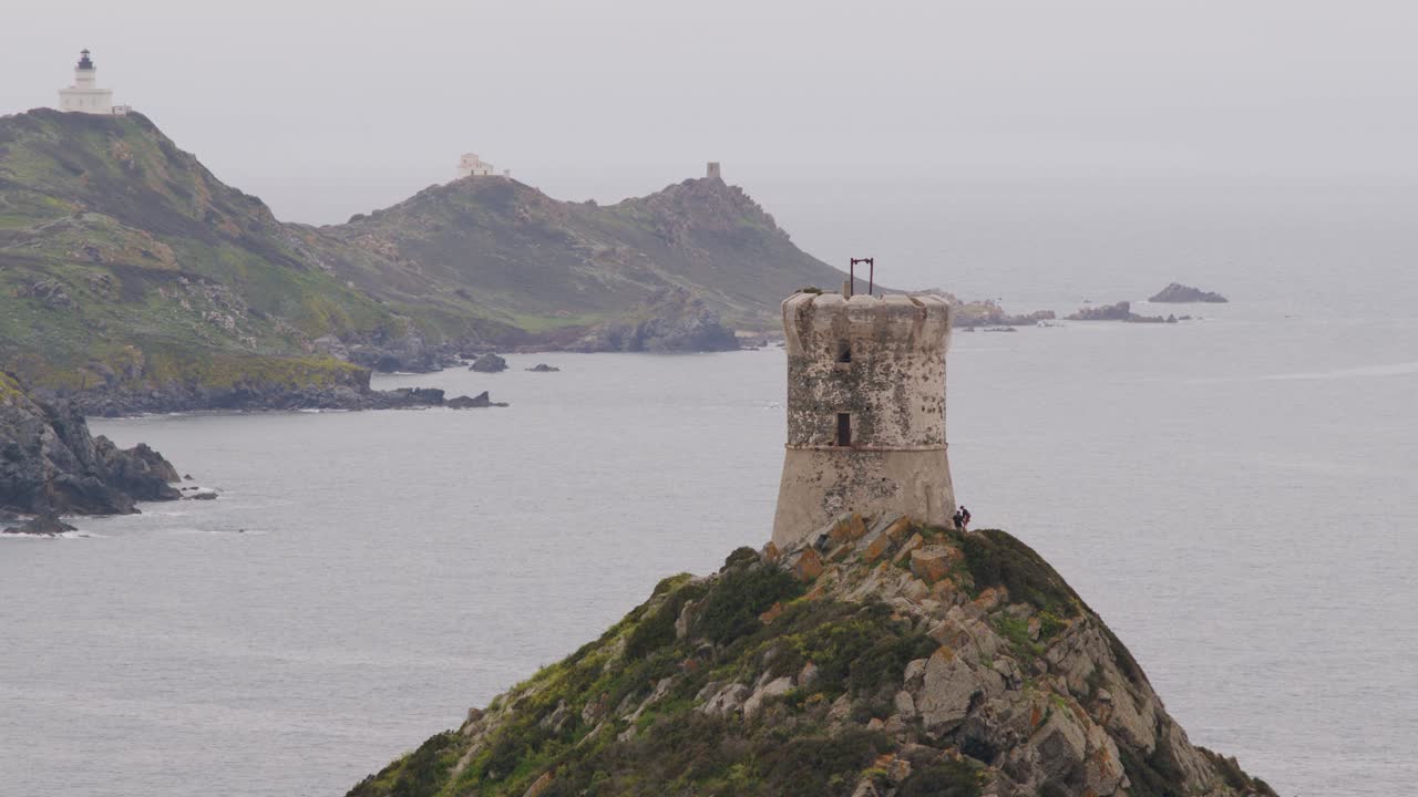 torre costera y faro en una isla montañosa