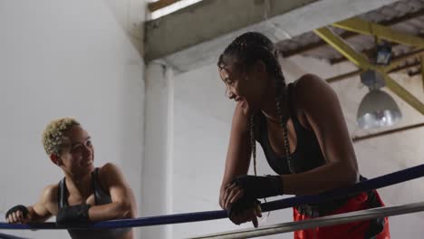 Two-mixed-race-women-discussing-in-boxing-ring