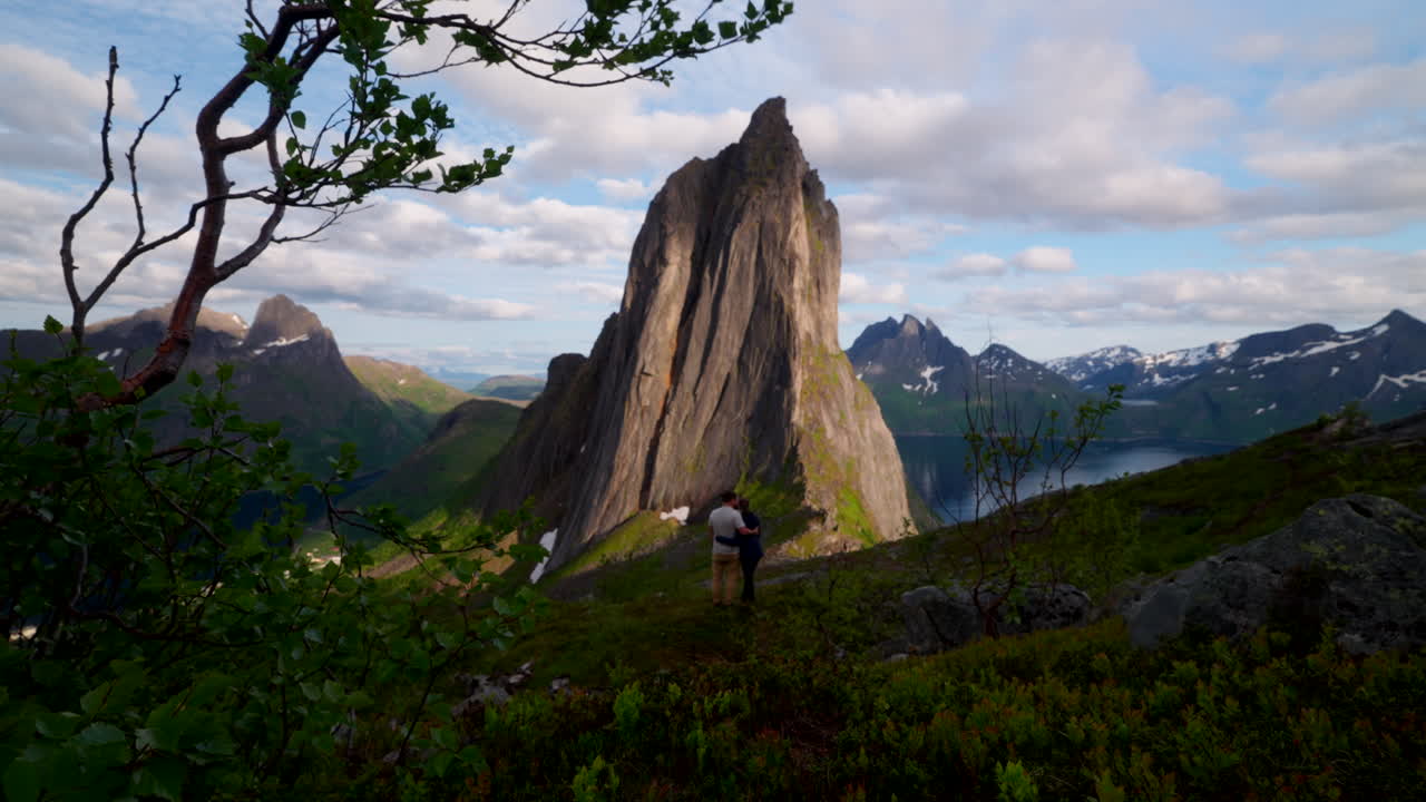 Affectionate influencer travel couple on hike with scenic view of Segla mountain
