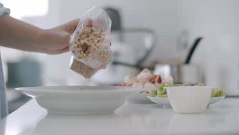 Making-breakfast-with-granola-and-fruit