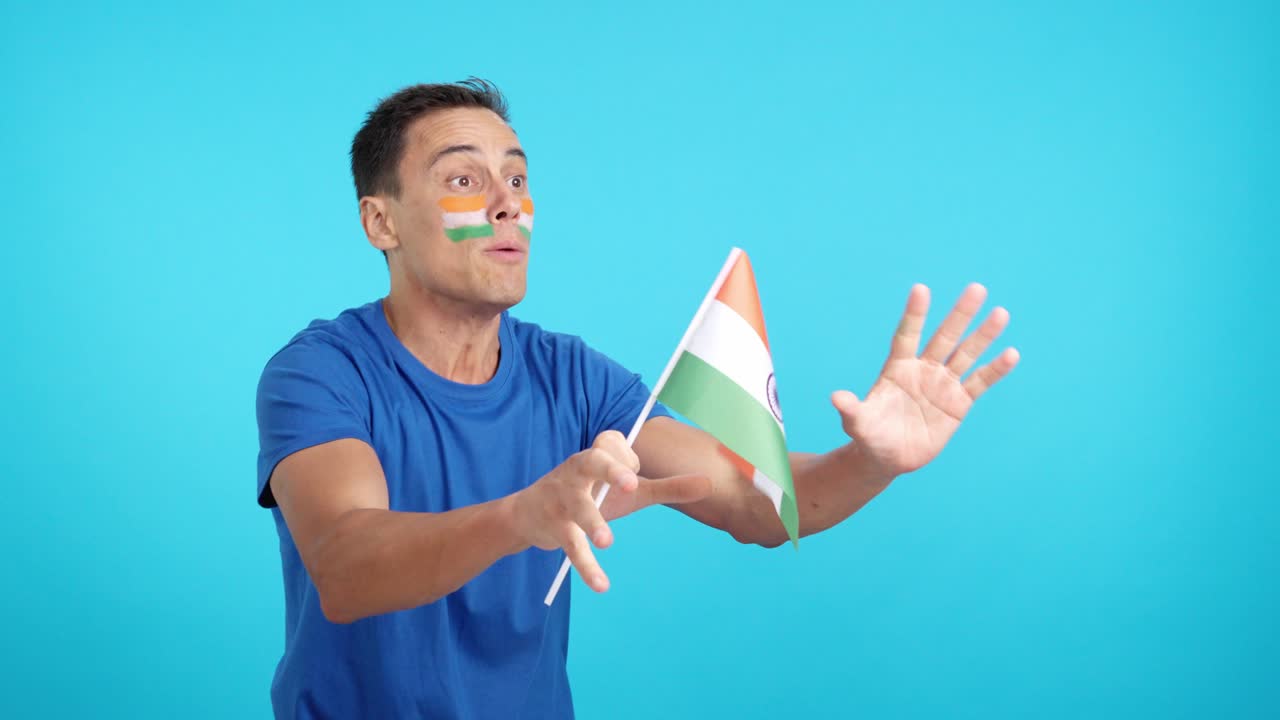Indian supporter screaming and waving a national flag looking away