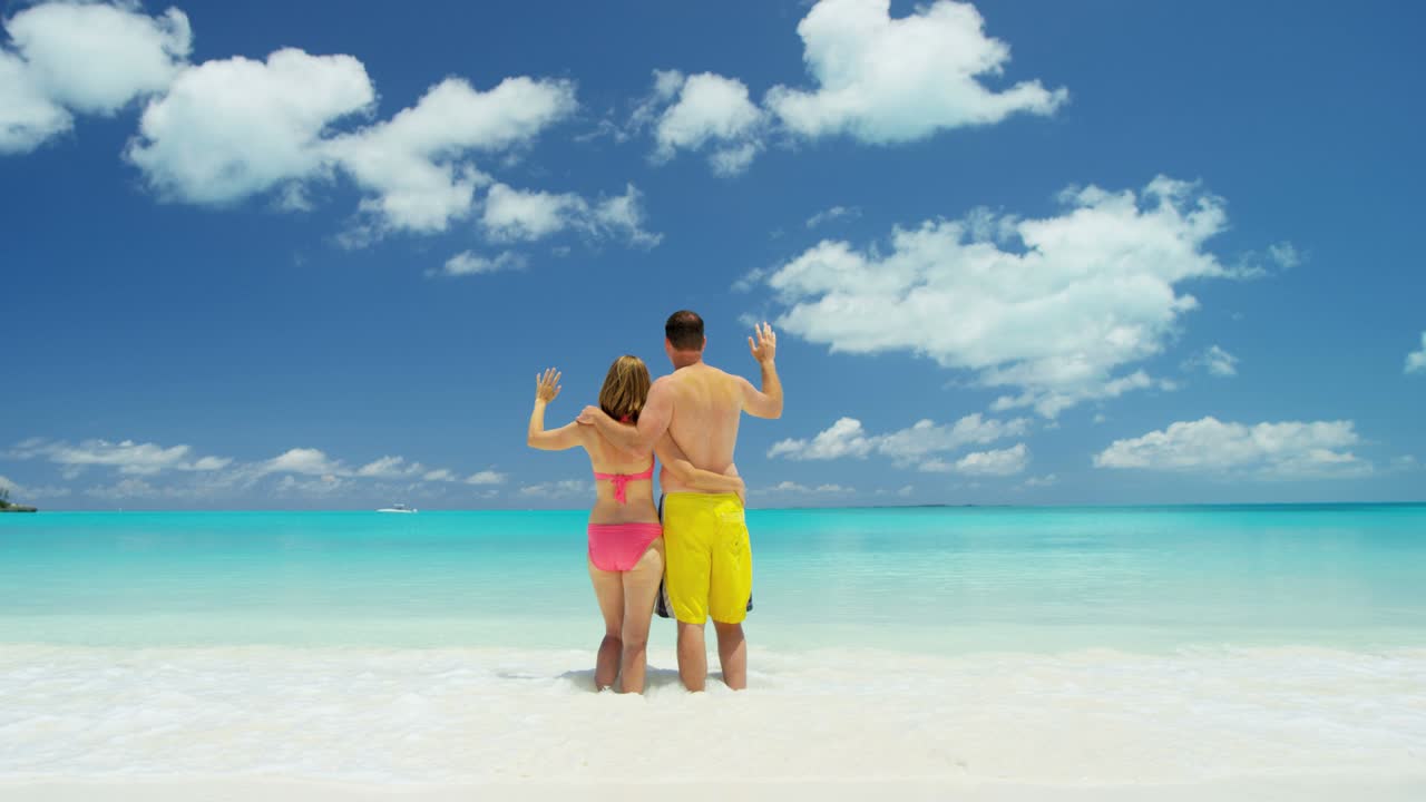 una pareja caucásica en trajes de baño en vacaciones de lujo en la playa.
