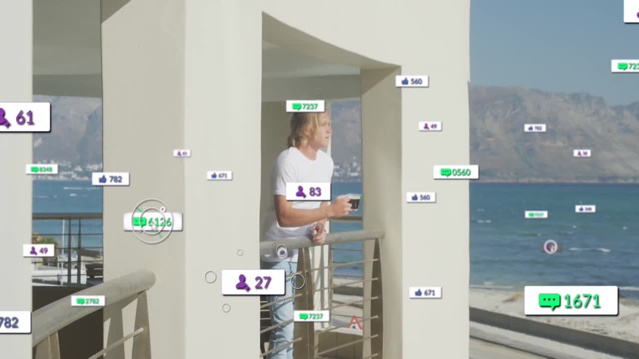 Man holding coffee cup on balcony overlooking ocean while social media marketing icons floating