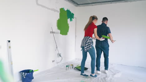 cheerful family dances painting white wall in modern room