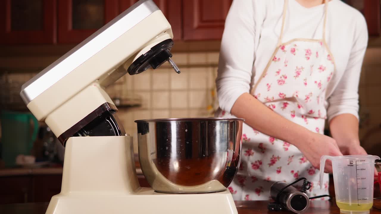 Kvinne bruker kjøkkenmaskin for å forberede ingredienser til baking