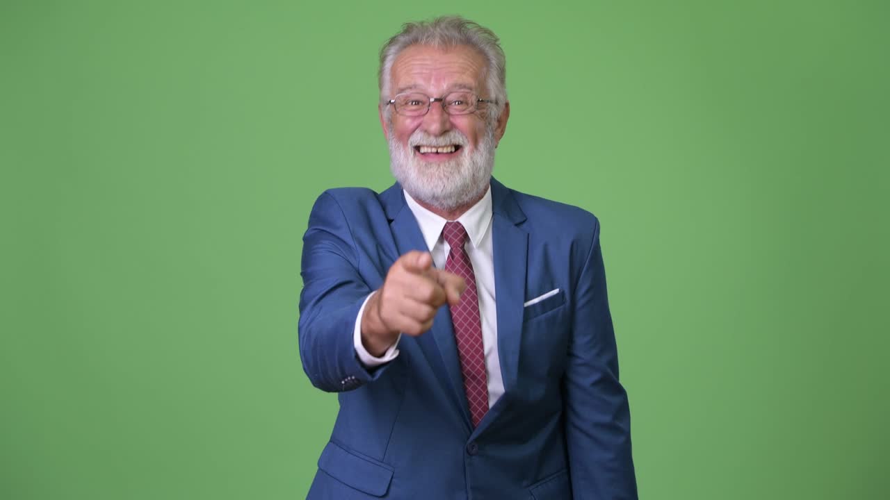 hombre de negocios barbudo y guapo contra un fondo verde.