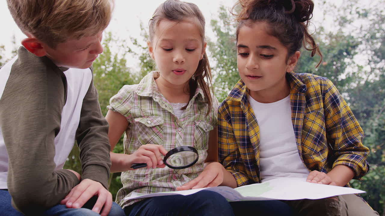 야외 활동 캠핑 여행 에 있는 어린이 들 의 그룹 이 함께 지도 를 보고 있다