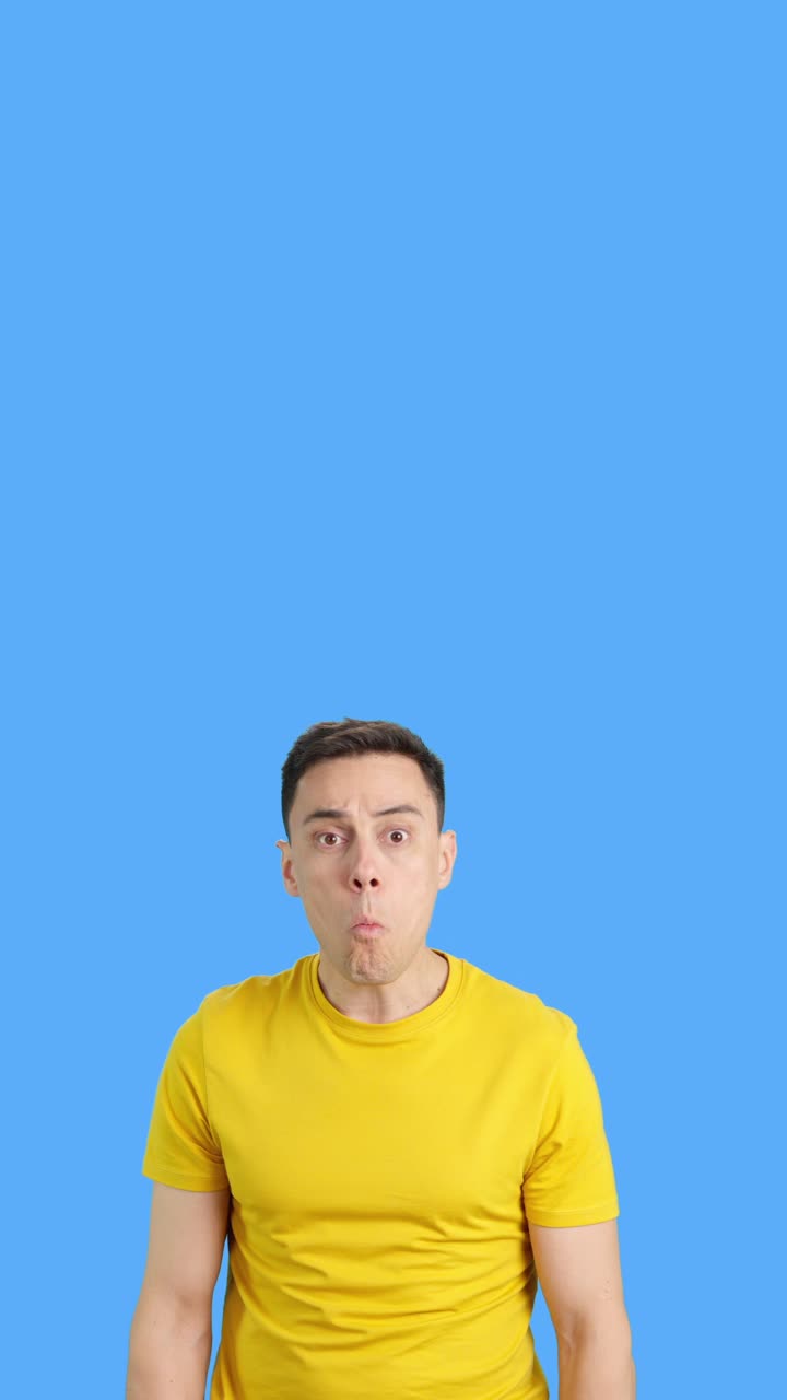 Man in yellow shirt with confused expression