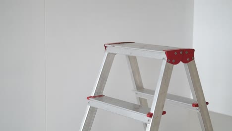 a silver step ladder with red accents