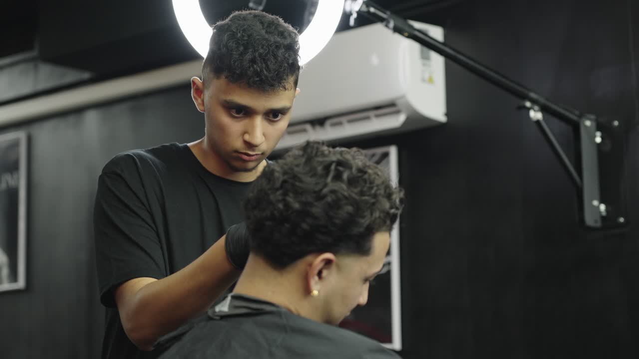 Frisør, der klipper hår i en barbersalon
