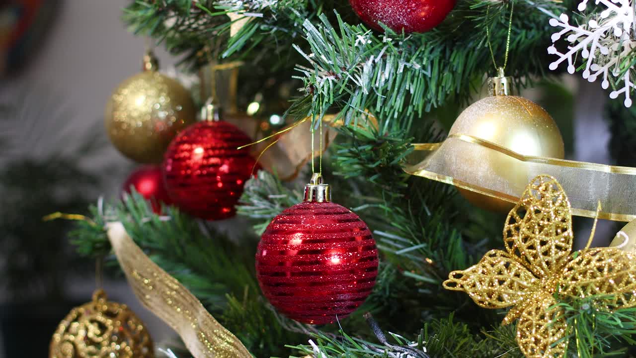cerca de poner un ornamento rojo en el árbol de navidad