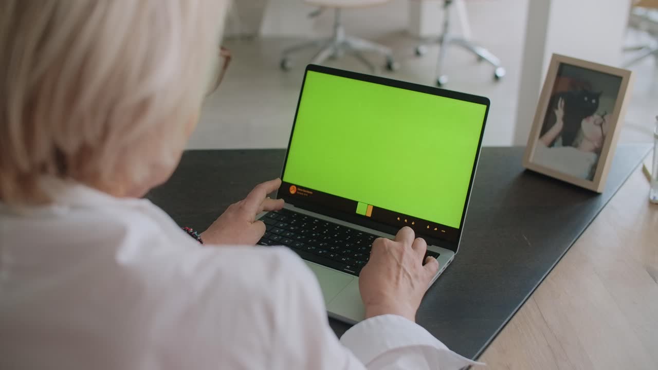 Senior Woman Working on Laptop with Green Screen