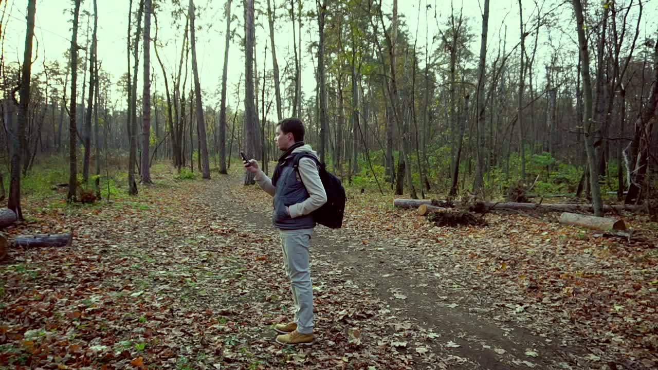 hombre tomando una foto en un bosque de otoño