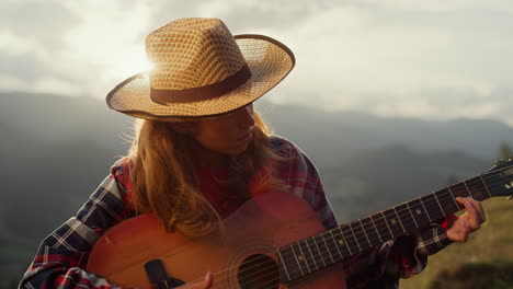 una mujer talentosa toca la guitarra. un guitarrista profesional actúa en las montañas.