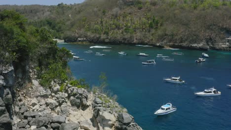 Antena-Que-Revela-Una-Playa-Tropical-De-Arena-Blanca-En-Crystal-Bay-Con-Barcos-Anclados-En-Nusa-Penida-Bali