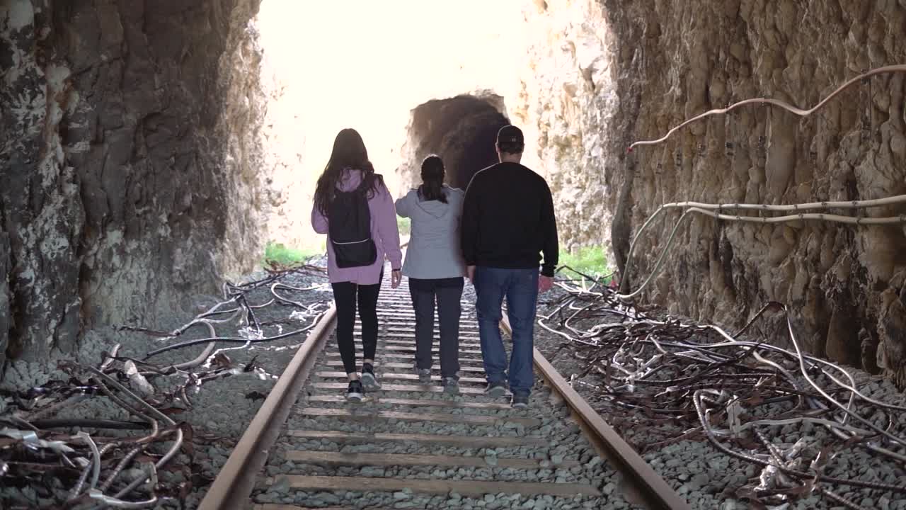 People walking on abandoned railway. Forgotten paths hiker group of backpacker friends. Hiking adventure in nature.