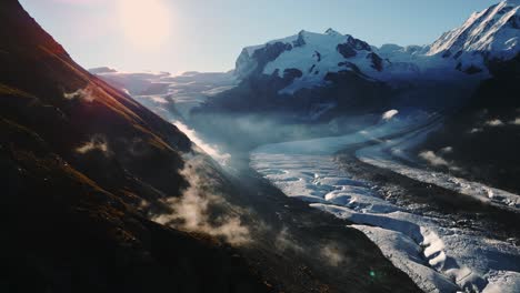 a breathtaking sunny view of a mountainous glacier landscape with mist rising in the valleys