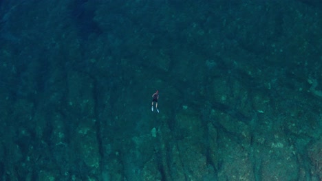 Toma-Aérea-De-Un-Nadador-Solitario-Frente-A-La-Costa-De-La-Isla-De-Losinj,-Croacia