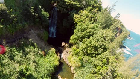 Fast-moving-drone-shot-of-a-luxurious-private-villa-on-the-edge-of-a-cliff-surrounded-by-lush-green-foliage