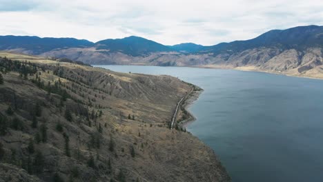 kamloops lake surrounded by mountains in the dry climate of the okanagan in british columbia in canada on a overcast day in summer