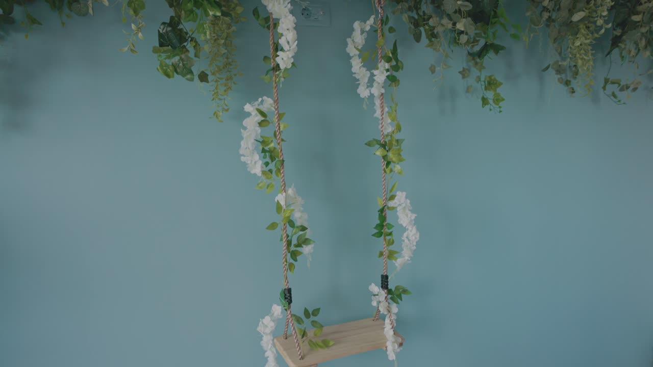 Wooden Swing Decorated With Artificial Flowers Hanging By The Wall Inside Beauty Salon