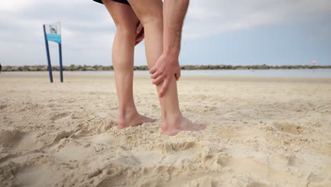 Stretching-downwards,-rubbing-calf-and-feet