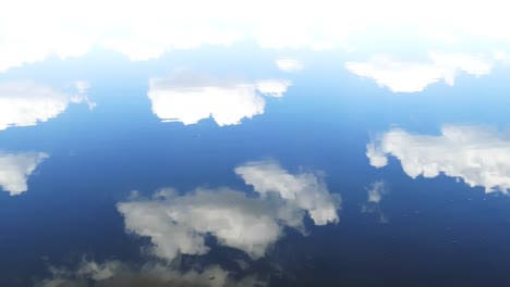 superficie del agua con el reflejo del cielo y las nubes