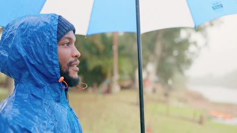 Rain,-umbrella-and-peace-with-black-man-in-nature