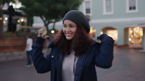 portrait of cheerful young mixed race woman smiling posing taking selfie photo using smartphone wearing fur coat