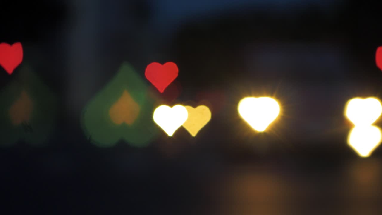 bokeh de hermosos corazones del camión en movimiento y los semáforos en la noche, el día de san valentín, el día de la boda o las redes sociales como concepto de fondo