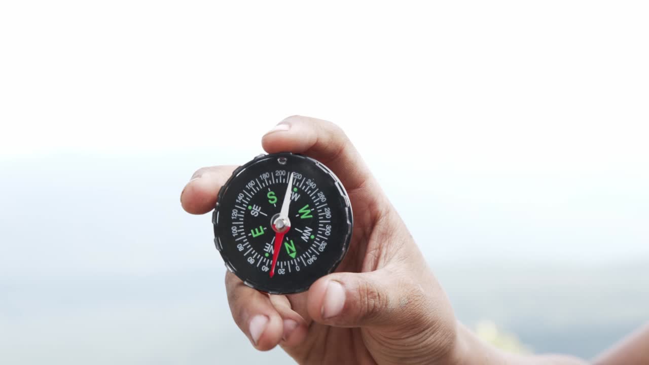 Hand holding a compass for travel.