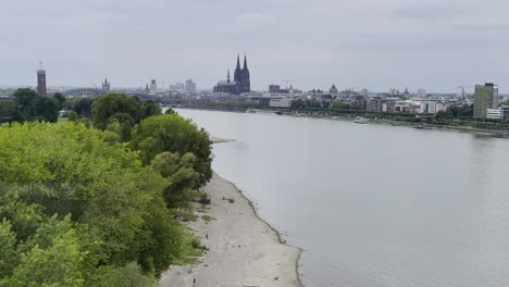 drone filmado sobre el rheinpark en colonia a través del rin a la estación principal de tren y la catedral de colonia