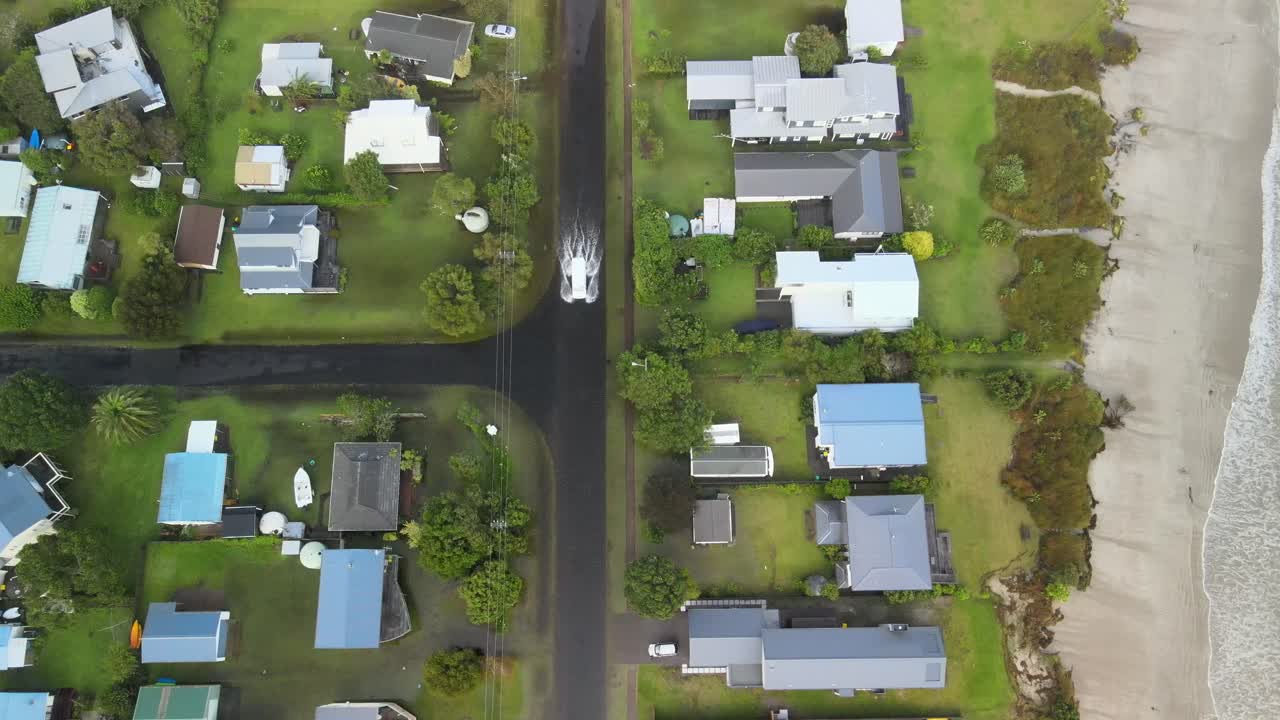 conducción de automóviles a través de las aguas de la inundación en la carretera de la playa después del ciclón gabrielle en la isla norte de nueva zelanda